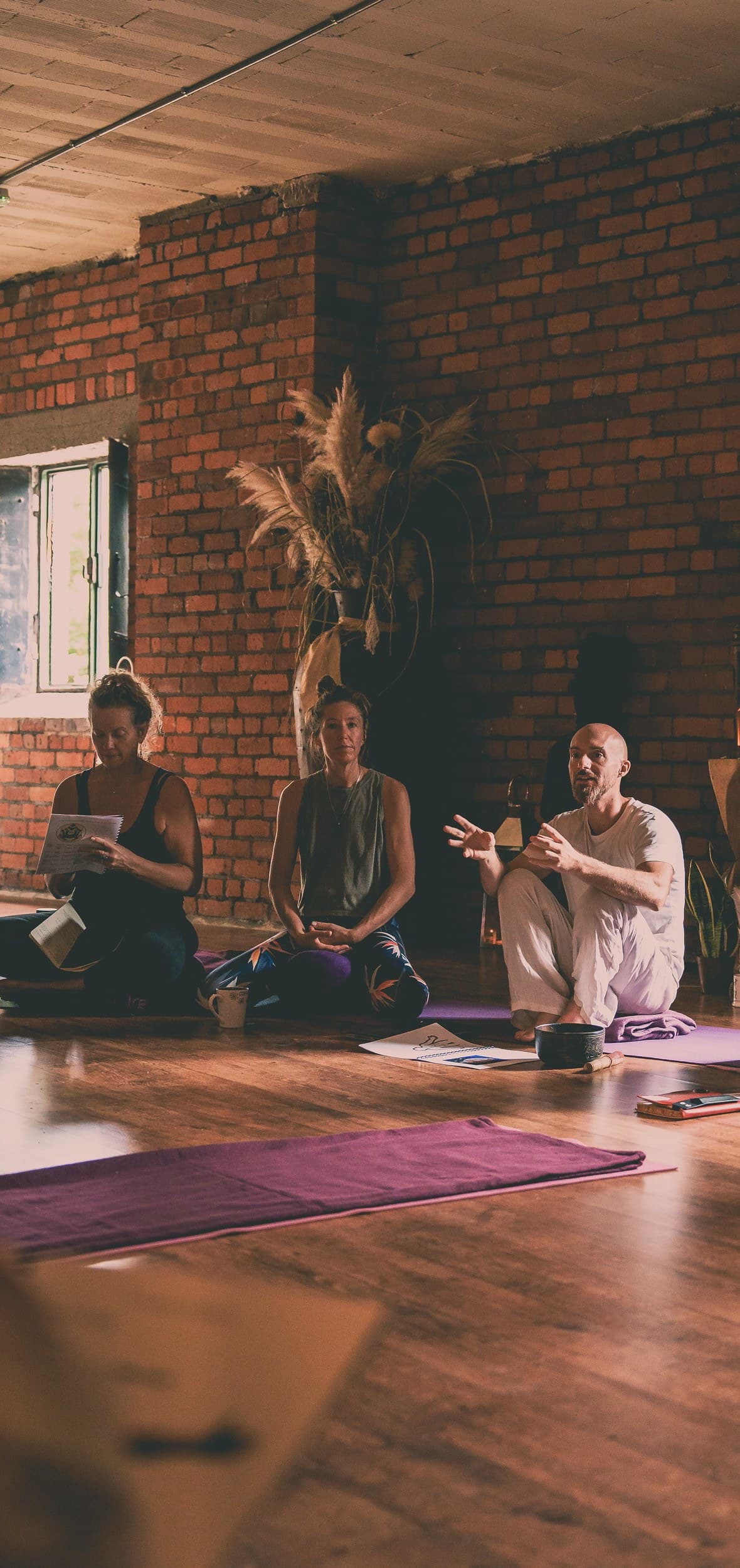 Ben North teaching a seated circle of students by candlelight.